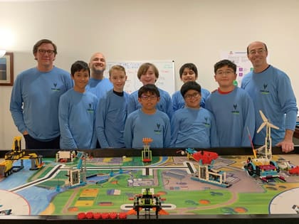 Students testing a robot on a FIRST LEGO League-style challenge table